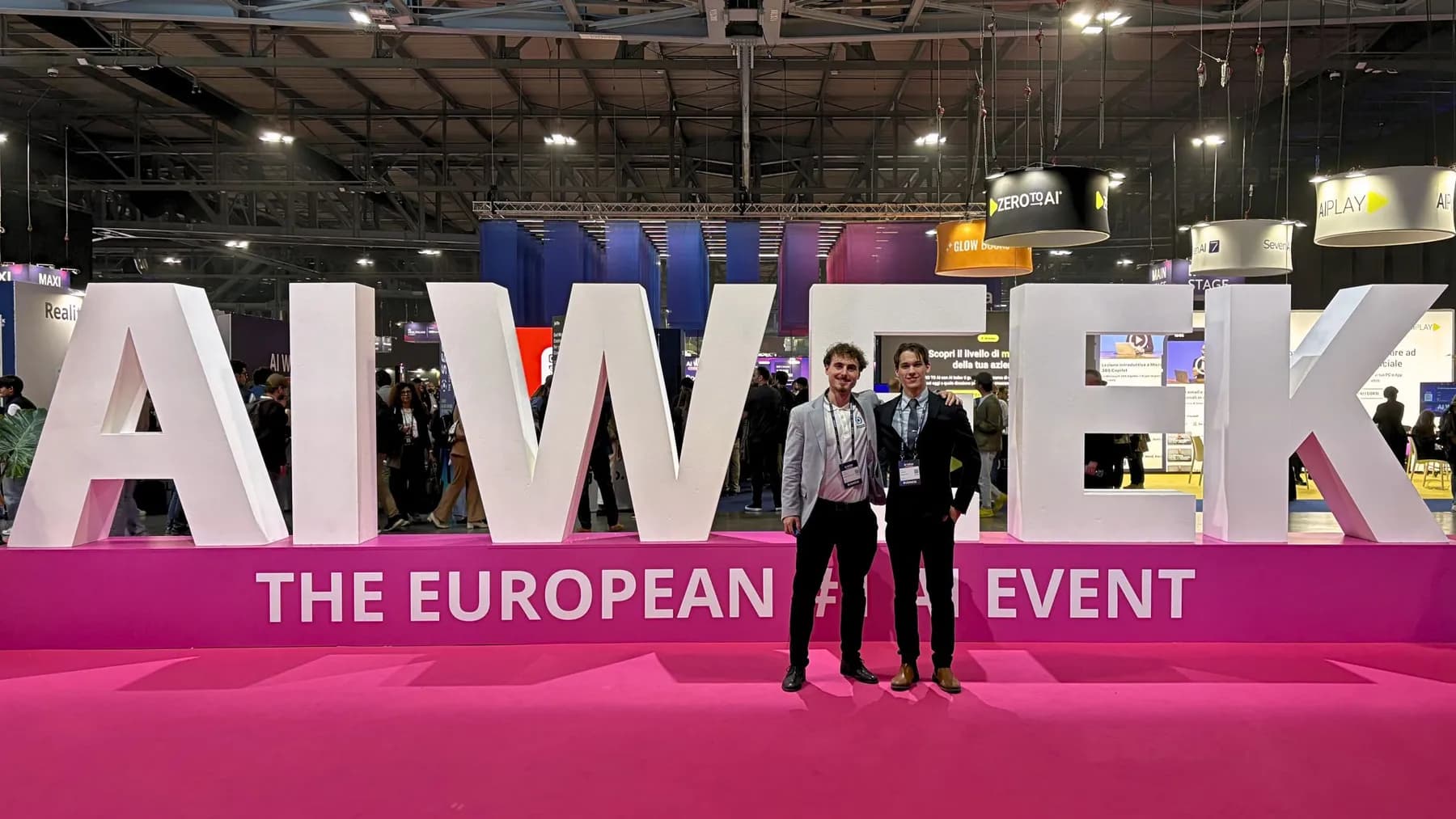Amedeo Cecconi e Philip Giuppini davanti all'insegna dell'AI Week a Fiera Milano Rho